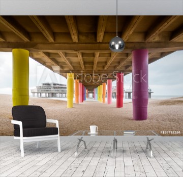 Picture of Shot under pier with color painted columns on the beach at sunset